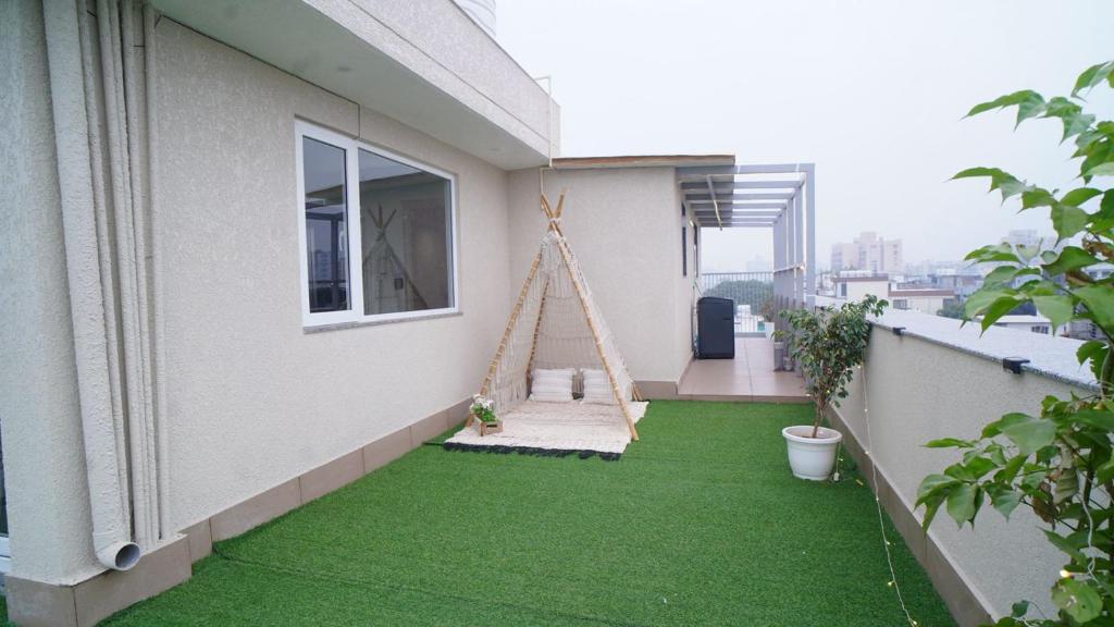 einen Balkon mit einem Garten mit grünem Gras in der Unterkunft Central suites with Terrace by Luxury Heights in Gurgaon