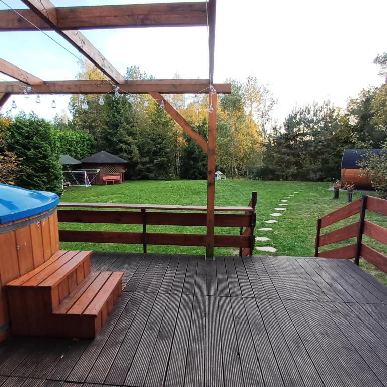a wooden deck with a bench and a gazebo at Borowy Las wita Was in Borowy Las