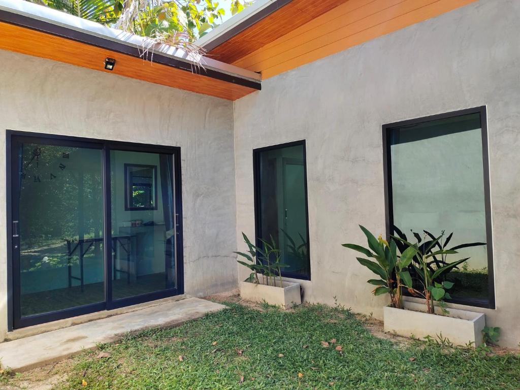a house with large glass windows on the side of it at Ingtara Lanta Valley in Ko Klang
