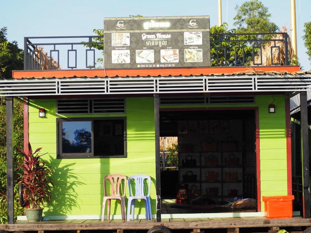 Prek ToalにあるGreen Houseの緑の建物の外に座る椅子2脚