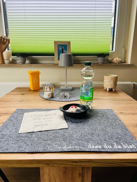 a table with a bottle of water on top of it at Appartement am Teich 2 in Krefeld