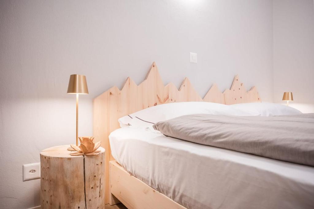 a bedroom with a large bed with a wooden headboard at Garni Pola in Campocologno