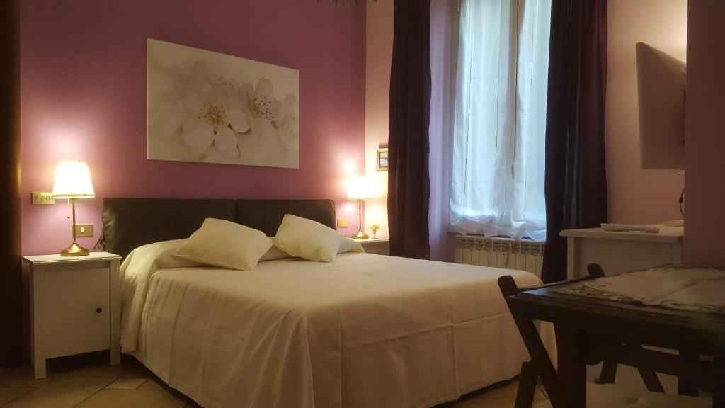 ミラノにあるBnButler - Sempione Apartment - Arco della Paceのベッドルーム1室(白いシーツと紫の壁のベッド1台付)