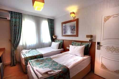a hotel room with two beds and a window at Agora Boutique Hotel & Bistro in Istanbul