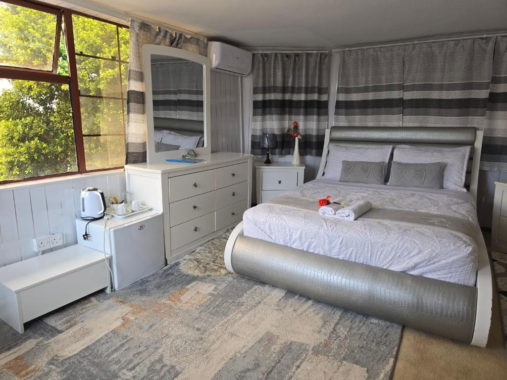 Apelles Palace Guest House - executive room 2 في Tlokweng: غرفة نوم بها سرير كبير وحمام