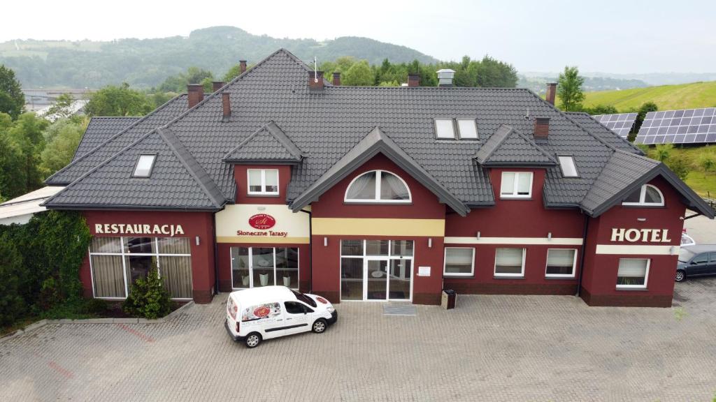 a hotel with a car parked in front of it at Hotel Słoneczne Tarasy in Grybów