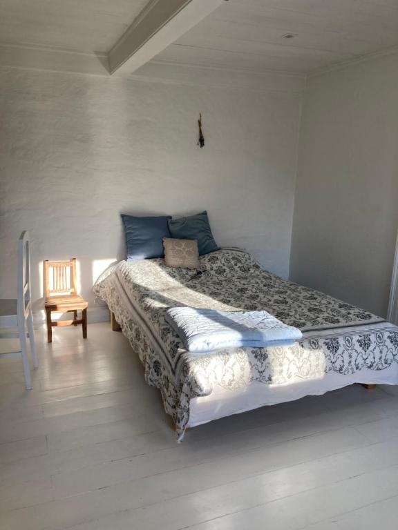 un dormitorio con una cama y una silla en 18th century gem with soul, en Ærøskøbing
