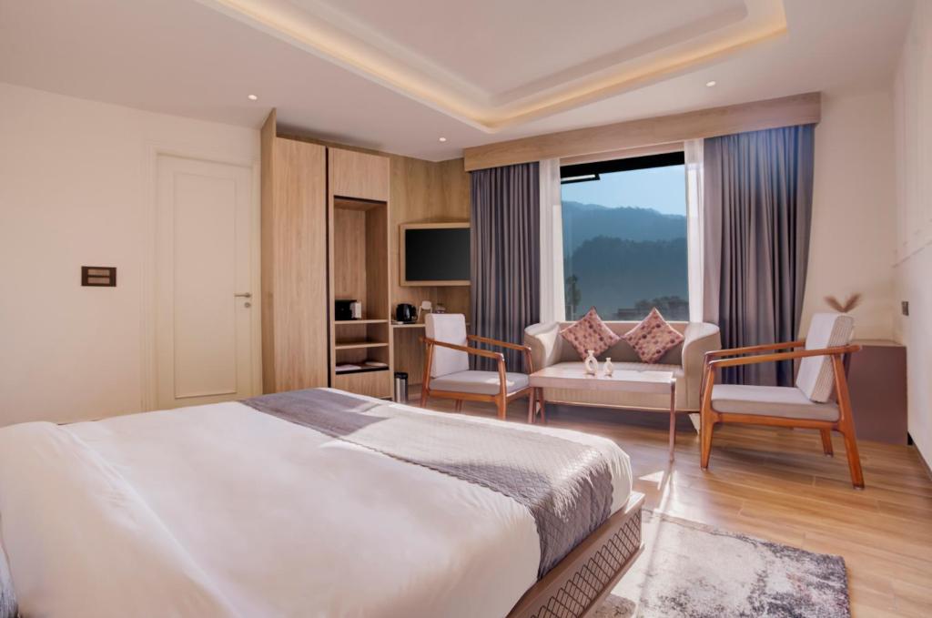a bedroom with a large bed and a living room at Hotel Urban chant in Rishīkesh