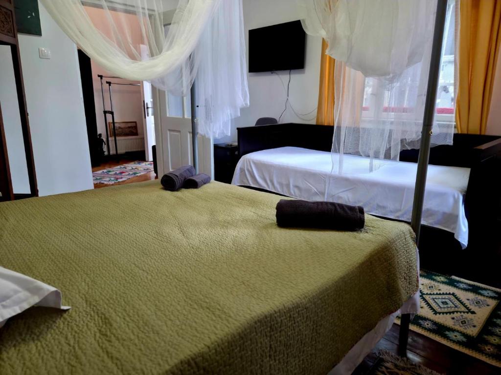 1 dormitorio con 2 camas y 1 cama con dosel en Simonette Maisonette - Mountain Retreat, en Buşteni