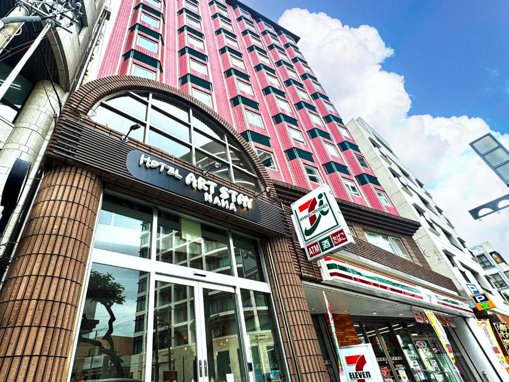 a tall building with a sign in front of it at Hotel Art Stay Naha Kokusai-Dori in Naha