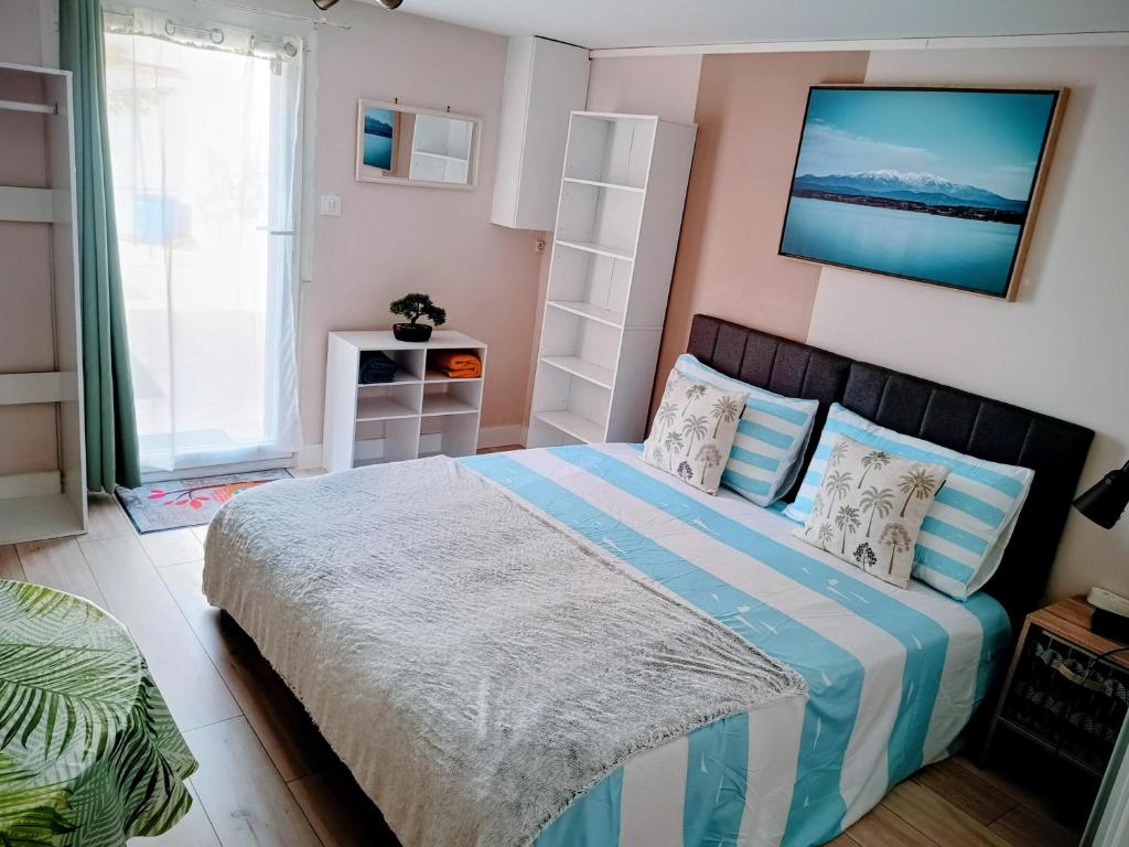 a bedroom with a bed with blue and white sheets at Studio cosy, tout équipé, WI-FI proche Clinique Saint-Pierre in Perpignan