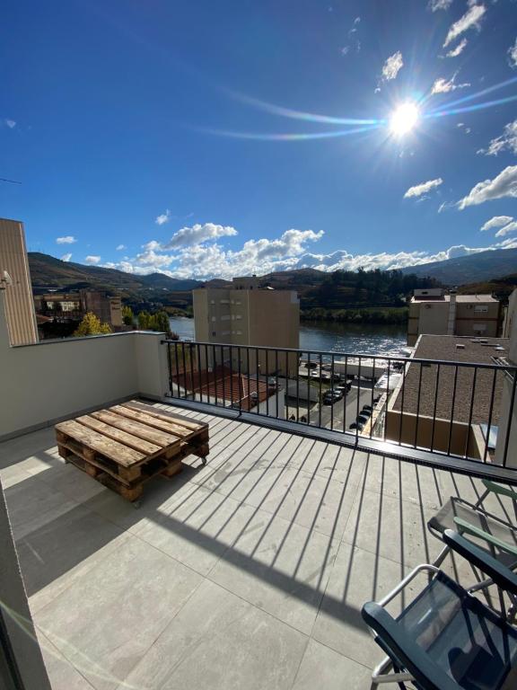 eine Terrasse mit einer Bank auf einem Gebäude in der Unterkunft Casa dos Camilos - Douro View Terrace House in Peso da Régua