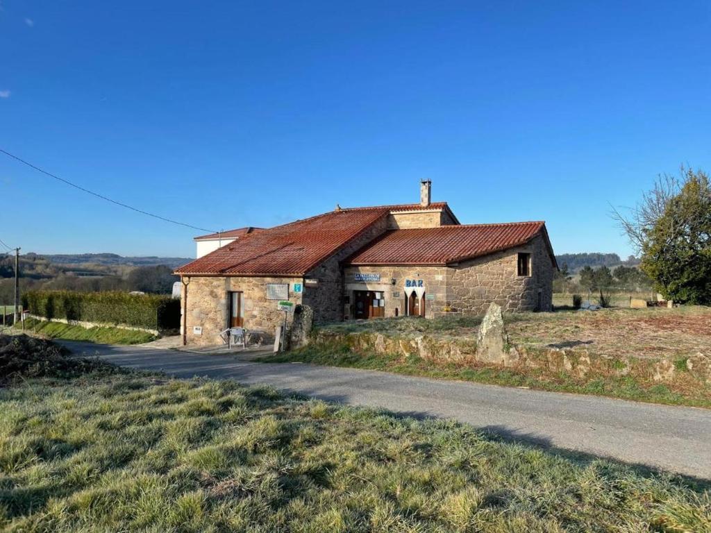 an old stone house on the side of a road at La pallota de san cristobal in Camino