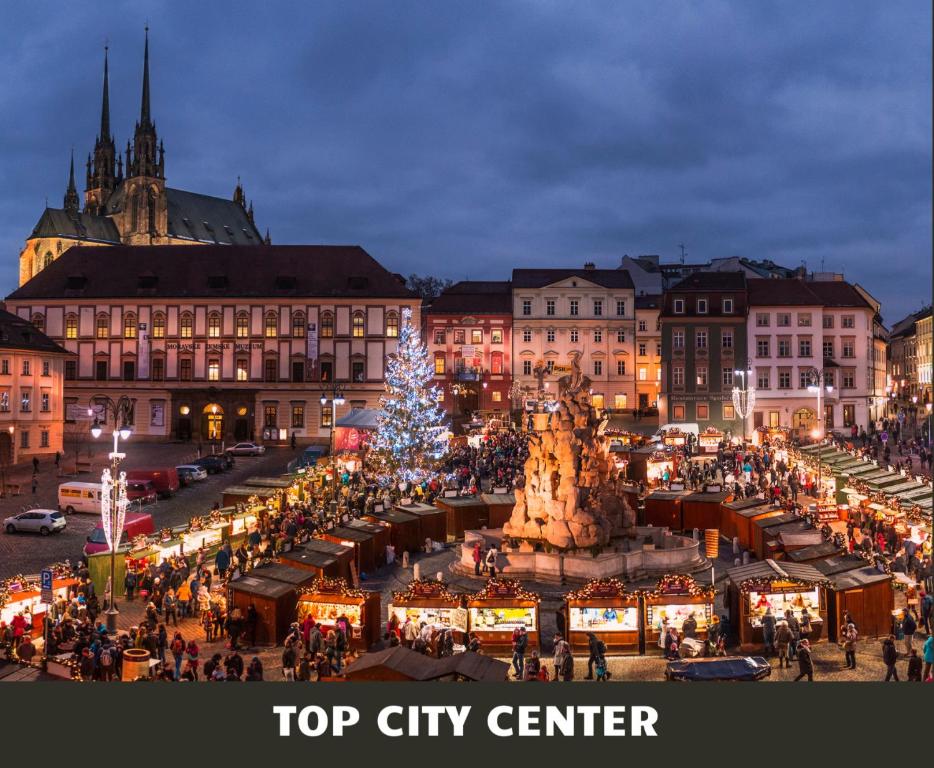 a christmas market in a city with a christmas tree at Grandezza Hotel Luxury Palace in Brno