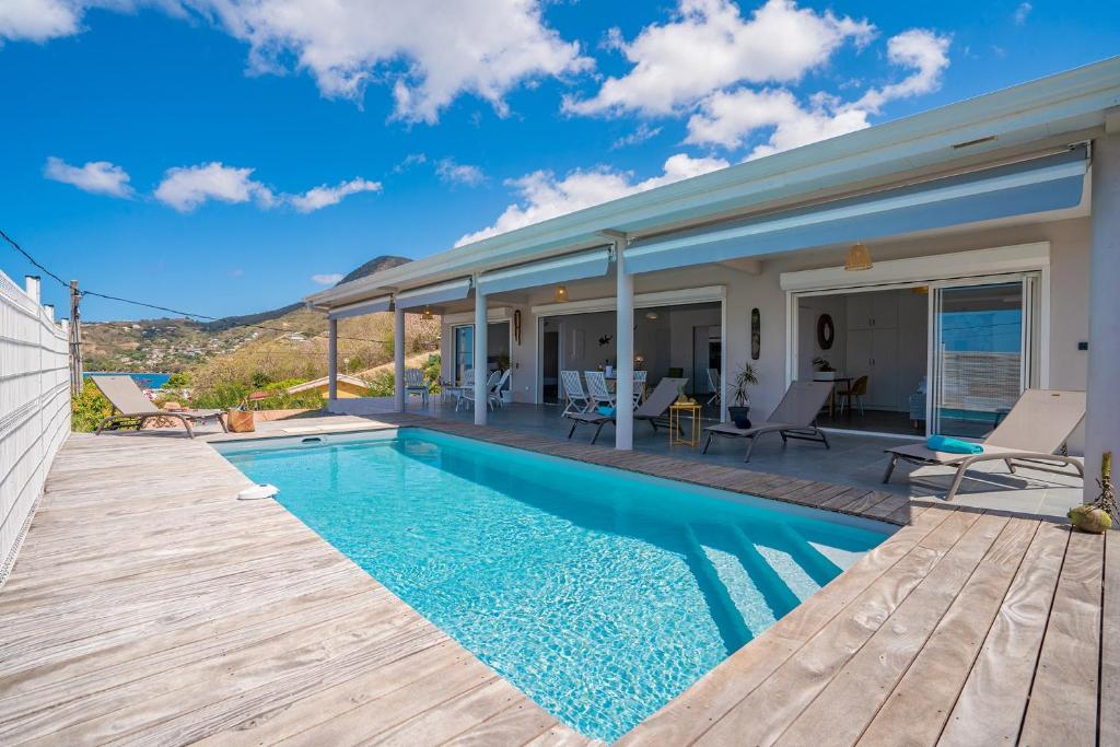 Villa Macaré في Quartier du Fond Fleuri: منزل به مسبح وسطح