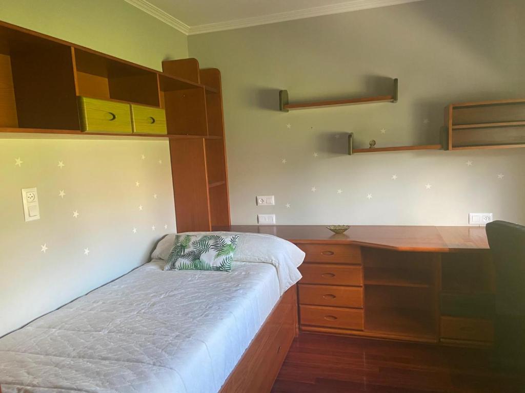 a bedroom with a bed and a wooden desk at Casa Vacacional O PIÑEIRO in Piñeiro