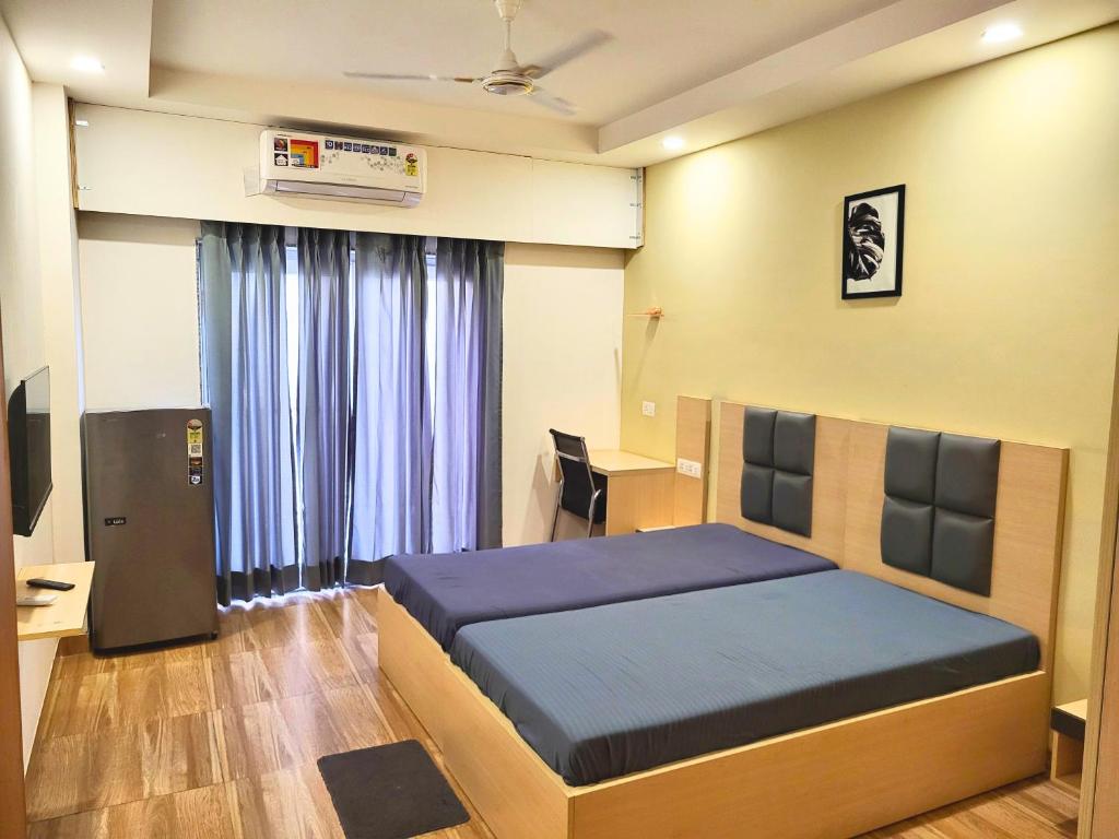 Un dormitorio con una cama y un escritorio con una computadora. en Kommune Living, en Gurgaon