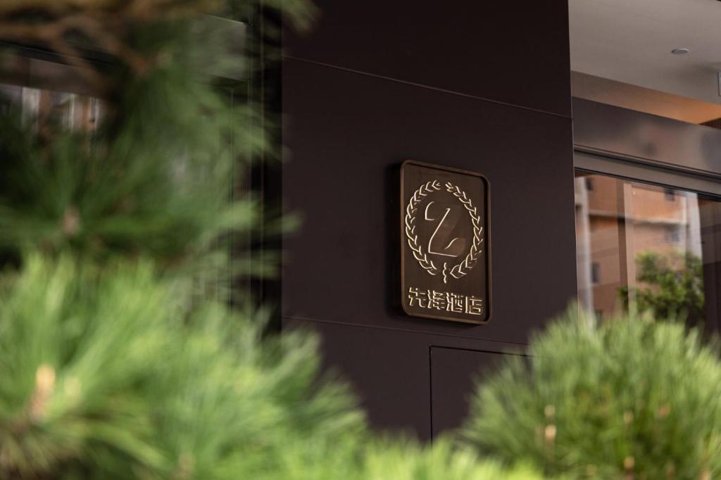 a sign on the side of a building with trees at 先泽酒店 in Huadu