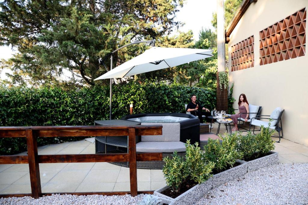 two people sitting at a table with an umbrella at Tognazzi Casa Vacanze - Casa Dante in Villa del Monte