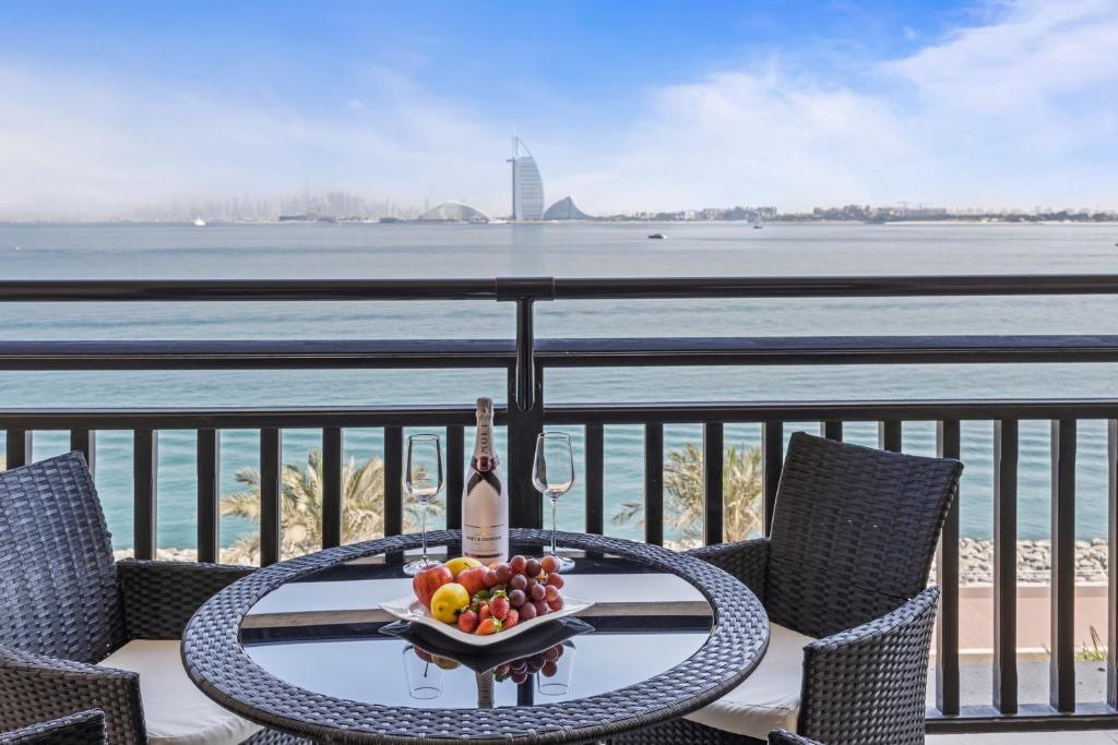 迪拜Burj View Luxury 1BR - Full Sea View Private Beach - Anantara Palm的阳台上的一张桌子上放着一碗水果