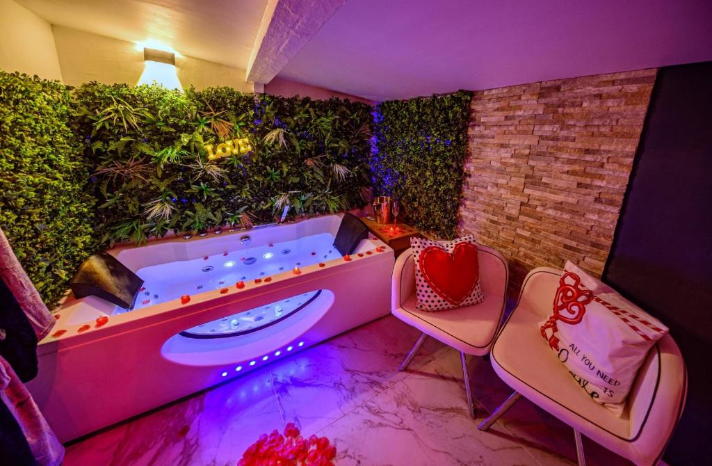 een jacuzzi in een kamer met 2 stoelen bij Love Room romantique avec jacuzzi - Arles centre in Arles