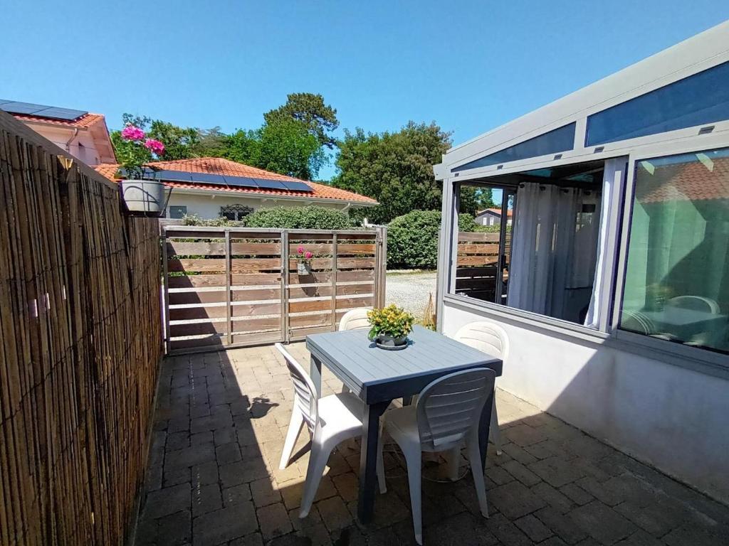 een tafel en stoelen op een terras met een caravan bij Gite charles in Capbreton