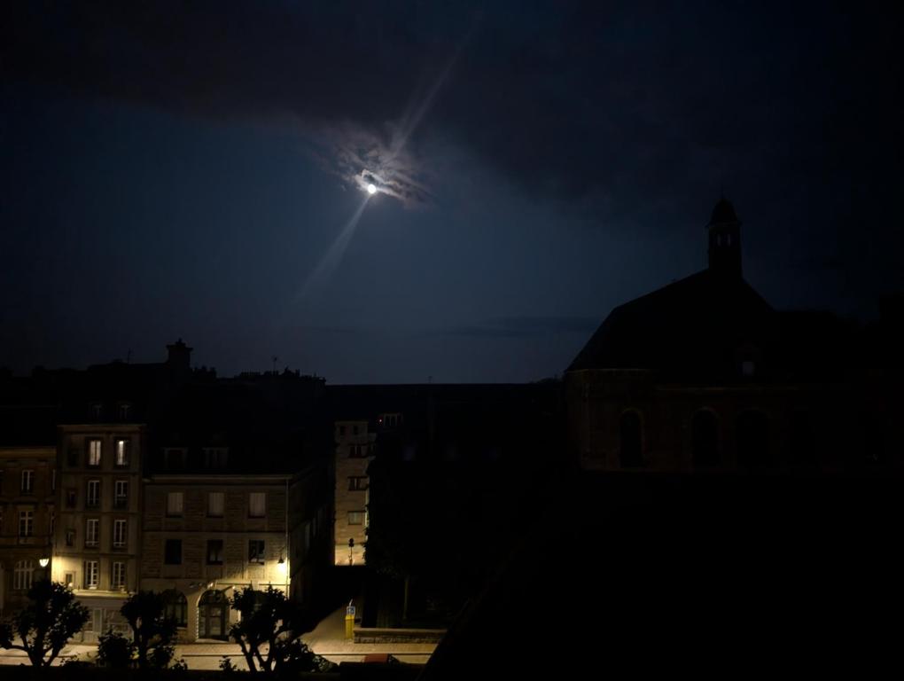 Una luna nel cielo sopra una città di notte di La pie hour a Saint Malo
