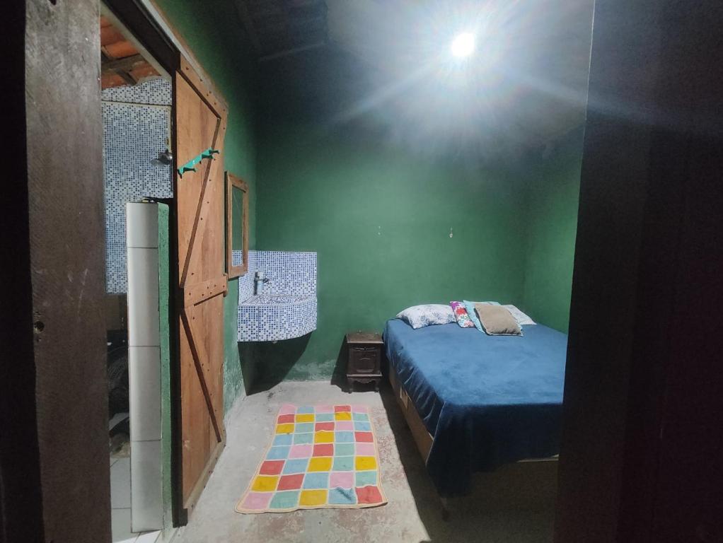 una camera da letto con un letto e una parete verde di Suite e Natureza Samsarah a Parati