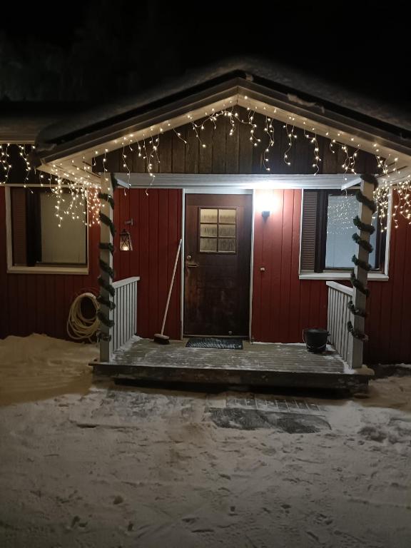 una casa roja con luces de Navidad en ella en Sulli apartment, en Rovaniemi