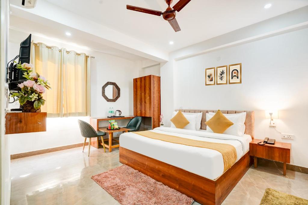 a hotel room with a bed and a desk at Hotel Breezy Heights Near IGI Delhi Airport by JIP in New Delhi