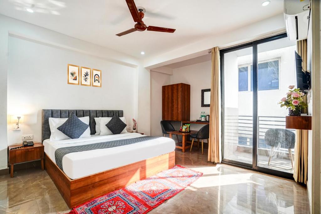 a bedroom with a bed and a large window at Hotel Breezy Heights Near IGI Delhi Airport in New Delhi