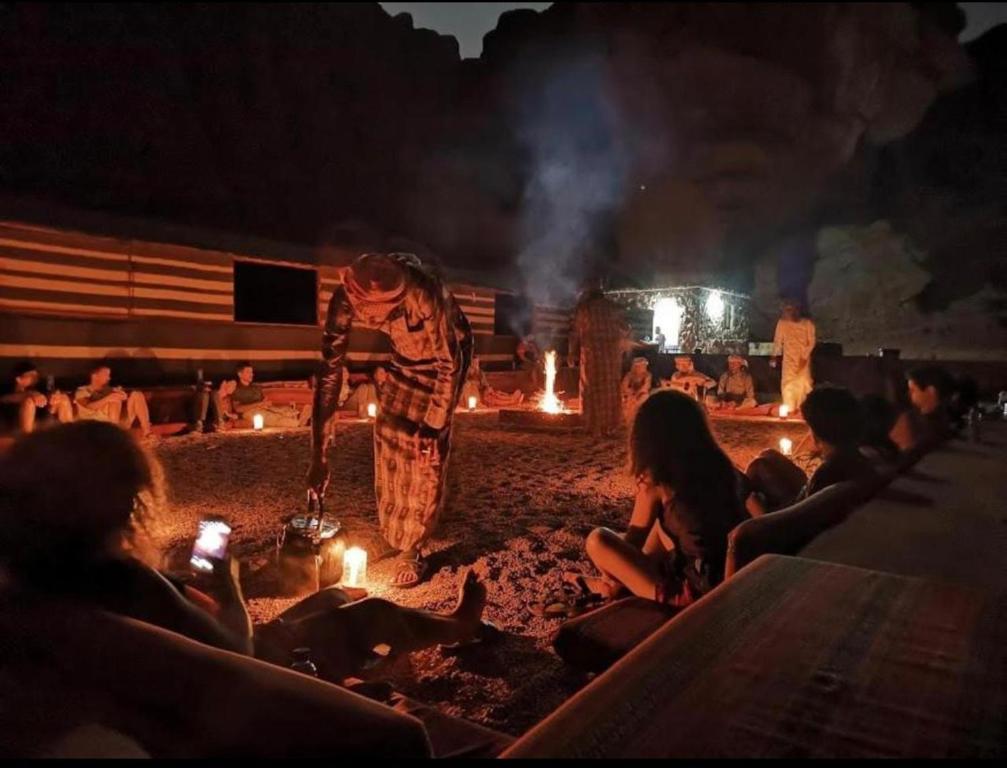 Un hombre parado frente a un fuego por la noche en Rum Night Style, en Wadi Rum