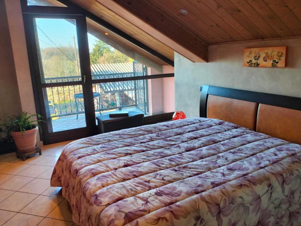 Un dormitorio con una cama grande y una ventana grande en Asti Centro, Monferrato - Light Home with AC, Wifi, Park, Pool, en Asti