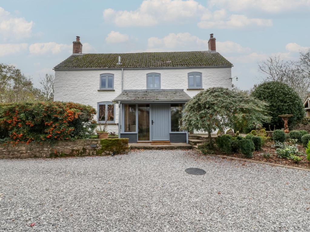een wit huis met een grindoprit bij Tawny Cottage in Llandenny