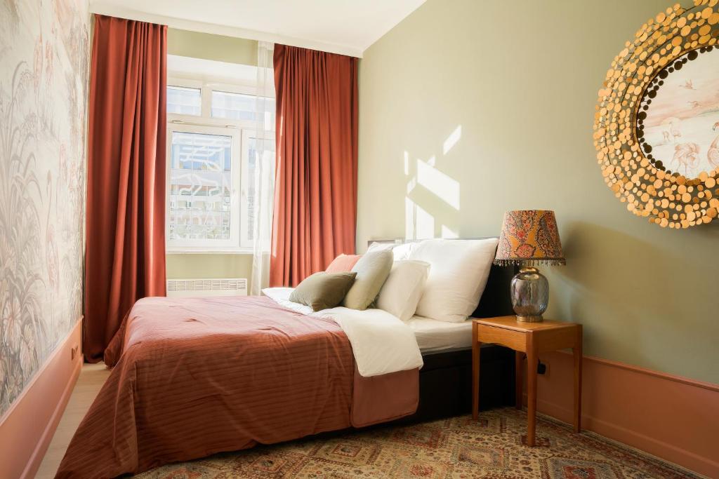 a bedroom with a bed with red curtains and a window at Flamingo Flat - Prague in Prague