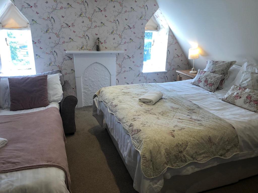 a bedroom with two beds and two windows at St Annes House Double Room 6 in Plymouth