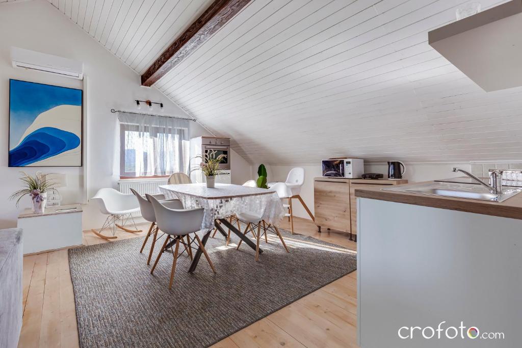 una cucina e una sala da pranzo con tavolo e sedie di Villa Mavi a Drežnik Grad