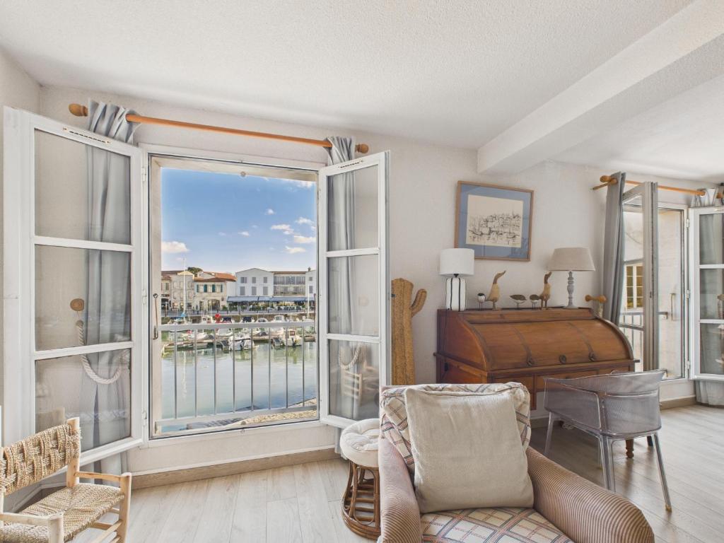a room with a large window and a bedroom with a bed at Au coeur du port, vue unique, appartement pour 6 in Saint-Martin-de-Ré