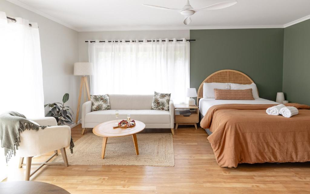 een slaapkamer met 2 bedden en een bank en een tafel bij Saltbush Retreat in Nelson Bay