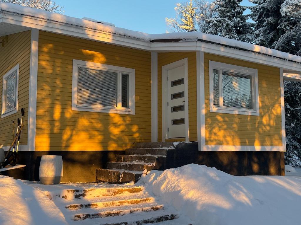 una casa con la neve davanti di Villa Lepikko a Rovaniemi