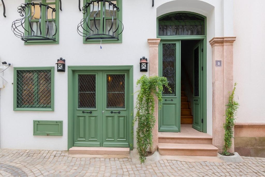 艾瓦勒克Defne Pansiyon Ayvalık的绿色门窗的房子