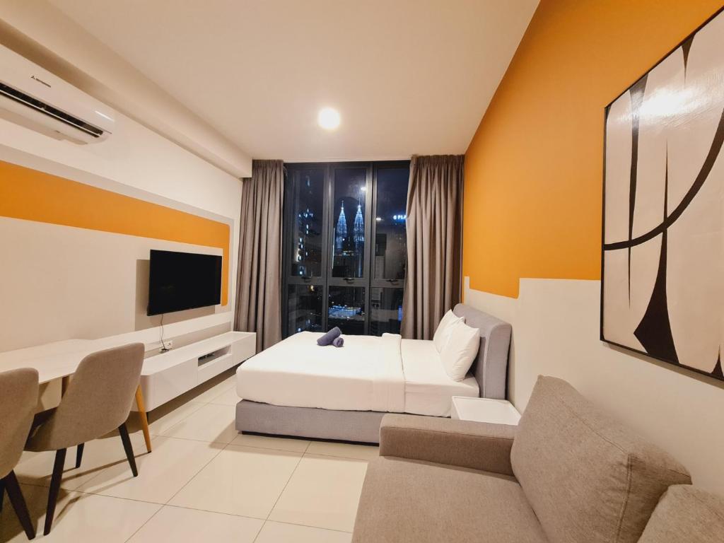 Un dormitorio con una cama, un escritorio y un televisor. en KLCC View City Center At Majestic residence, en Kuala Lumpur