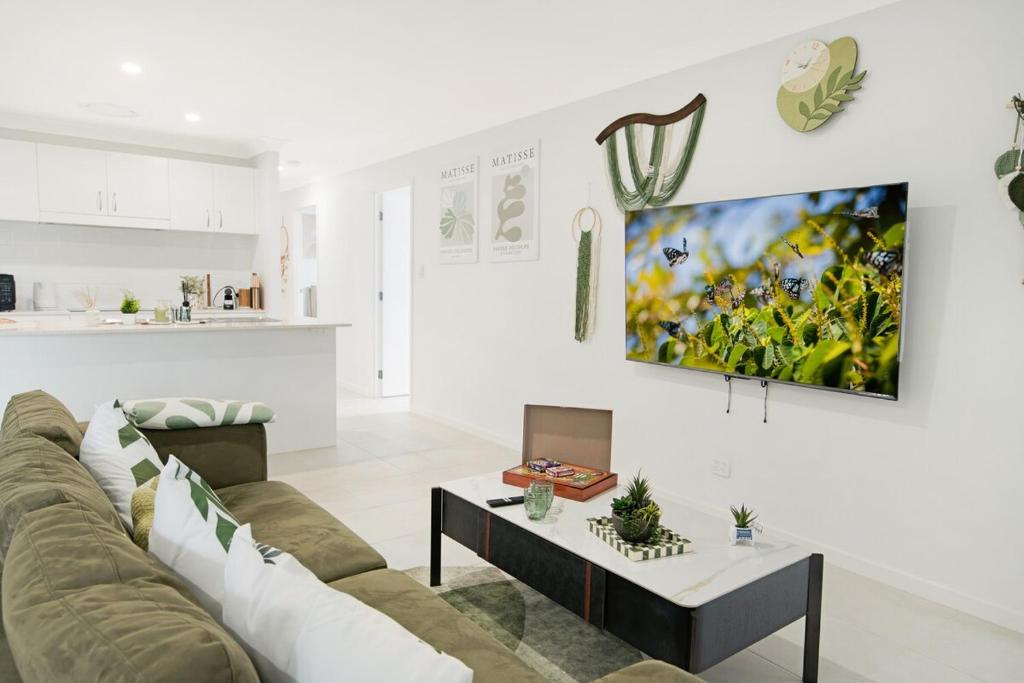 MarsdenLogan Reserv 5BR Near Large Business District Fully Air-Conditioned With Parking的客厅里有一张沙发和一张桌子。