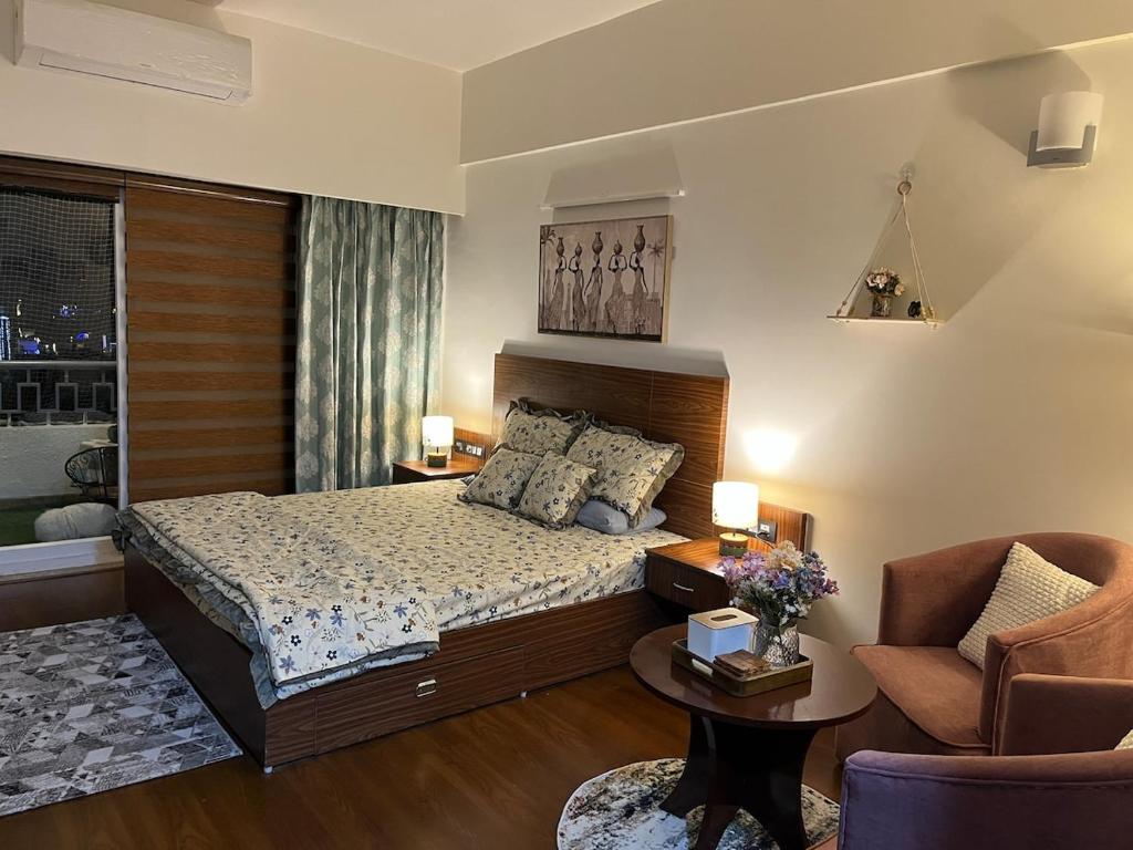 a bedroom with a bed and a couch and a chair at Bs BnB Luxury Studio Apartment in Dehradun