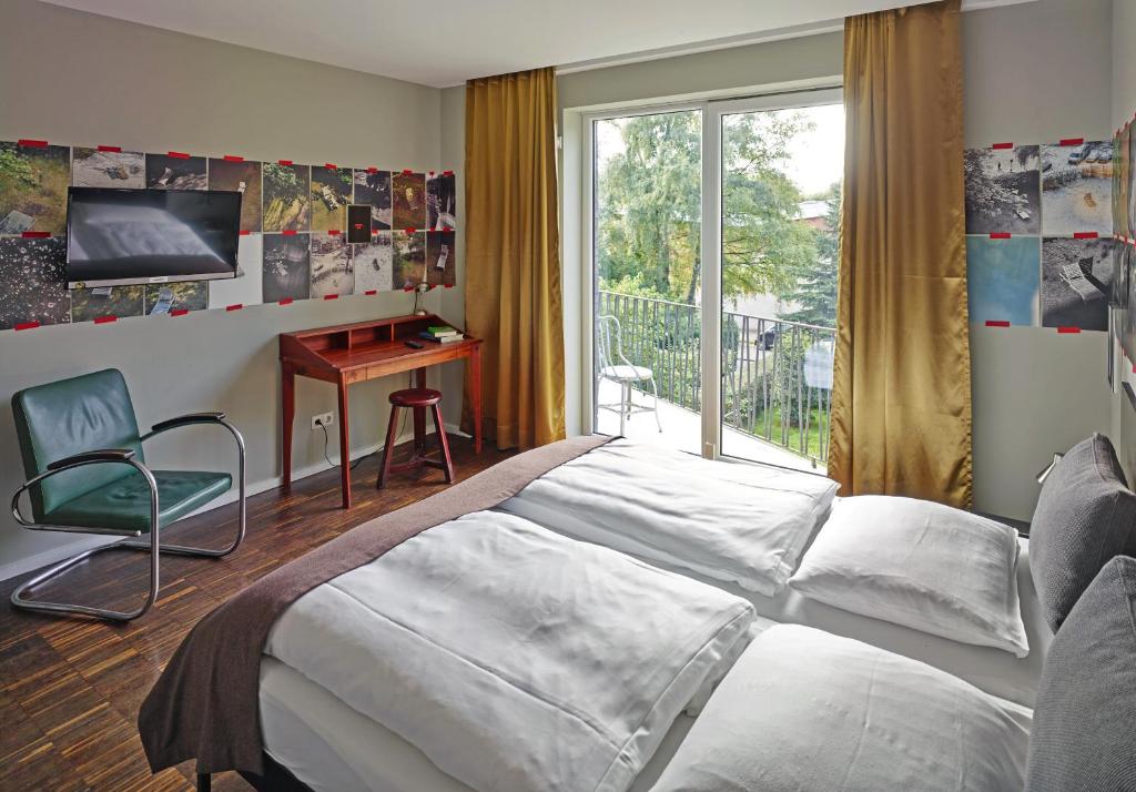 a bedroom with a bed and a desk and a window at Das kleine Schwarze - Bed & Breakfast in Hamburg
