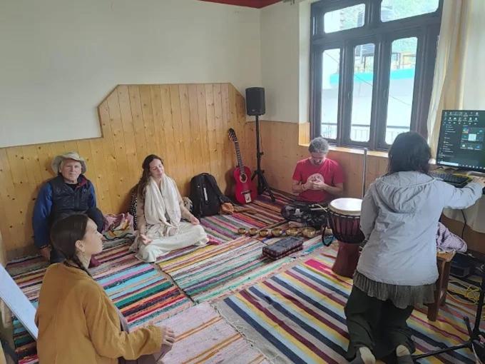 达兰萨拉DharteHouse Villa for Conscious Living and Events的一群人坐在一个房间里地板上