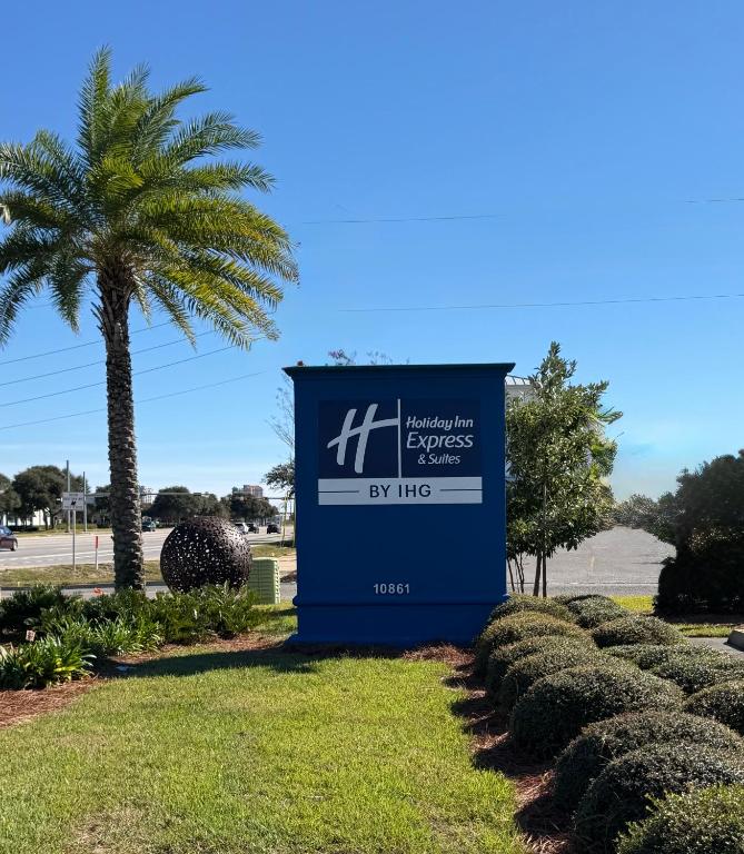 a sign at the entrance to a resort with a palm tree at Holiday Inn Express & Suites Destin - Miramar Beach by IHG in Destin