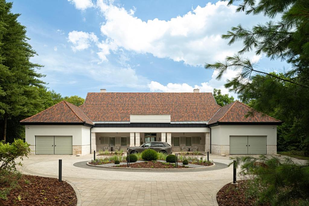 une maison avec un toit rouge et une allée dans l'établissement Avalon Luxury Villa, à Miskolc