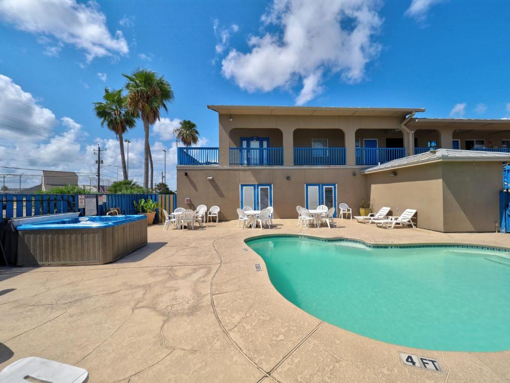 a house with a swimming pool in front of a house at Alister Square Inn in Port Aransas