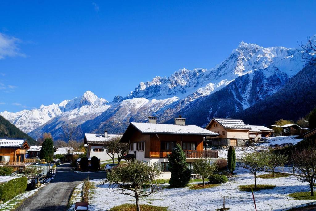 a village with snow covered mountains in the background at Charming Chalet With Garden In Les Houches in Les Houches
